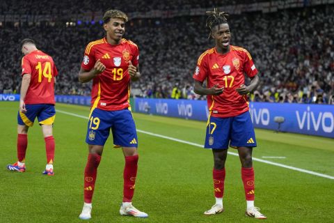 Spain's Nico Williams, right, celebrates with his teammate Lamine Yamal after scoring his side's opening goal during the final match between Spain and England at the Euro 2024 soccer tournament in Berlin, Germany, Sunday, July 14, 2024. (AP Photo/Matthias Schrader)