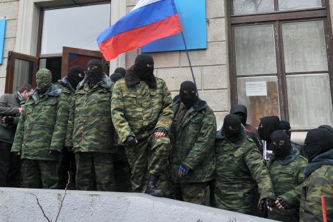 TOPSHOTS Unidentified masked individuals hold a Russian flag as they block the Trade Union building in Simferopol, the administrative center of Crimea, on March 1, 2014. Russia's parliament on March 1 gave President Vladimir Putin the go-ahead to send troops into Ukraine, despite a warning from Washington that such a deployment would results in "costs" for Moscow. The stark escalation of the ex-Soviet country's three-month political crisis came amid growing instability in Ukraine's predominantly Russian peninsula of Crimea that has housed Kremlin navies for nearly 250 years. AFP PHOTO/ GENYA SAVILOVGENYA SAVILOV/AFP/Getty Images