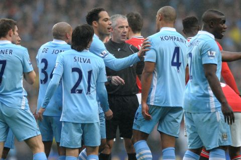 Referee Chris Foy (C) is surrounded by Manchester City players as he sends off City's Belgian midfielder Vincent Kompany (CR) during the English FA Cup football match between Manchester City and Manchester United at The Etihad Stadium in Manchester, north-west England on January 8, 2012.  AFP PHOTO / PAUL ELLIS

RESTRICTED TO EDITORIAL USE. No use with unauthorized audio, video, data, fixture lists, club/league logos or live services. Online in-match use limited to 45 images, no video emulation. No use in betting, games or single club/league/player publications. (Photo credit should read PAUL ELLIS/AFP/Getty Images)