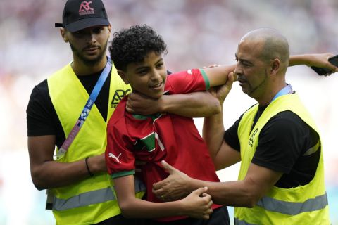 Stewards catch a pitch invader during the men's Group B soccer match between Argentina and Morocco at Geoffroy-Guichard Stadium at the 2024 Summer Olympics, Wednesday, July 24, 2024, in Saint-Etienne, France. (AP Photo/Silvia Izquierdo)