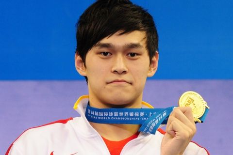 China's gold medalist Sun Yang holds his medal on the podium during the award ceremony for the final of the men's 1500-metre freestyle swimming event in the FINA World Championships at the indoor stadium of the Oriental Sports Center in Shanghai on July 31, 2011. Sun won the men's 1500m freestyle title in world record time, clocking 14min 34.14sec. 
 AFP PHOTO / MARK RALSTON (Photo credit should read MARK RALSTON/AFP/Getty Images)