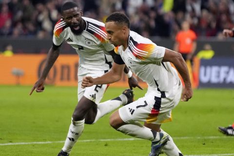 Germany's scorer Jamie Leweling, right, celebrates with teammate Antonio Ruediger after scoring the opening goal during the UEFA Nations League group 3 soccer match between Germany and The Netherlands in Munich, Germany, Monday, Oct. 14, 2024. (AP Photo/Matthias Schrader)