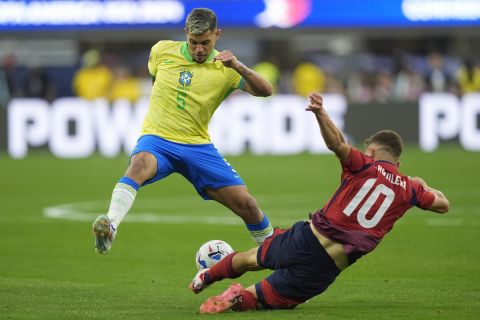 Brazil's Bruno Guimaraes, left, and Costa Rica's Brandon Aguilera battle for the ball during a Copa America Group D soccer match Monday, June 24, 2024 in Inglewood, Calif. (AP Photo/Ryan Sun)