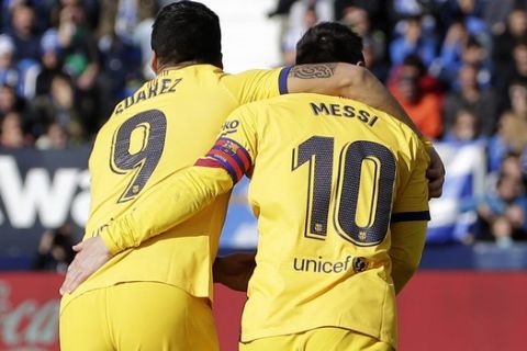 Barcelona's Luis Suarez, left, celebrates with Barcelona's Lionel Messi after scoring his side's opening goal during a Spanish La Liga soccer match between Leganes and FC Barcelona at the Butarque stadium in Madrid, Spain, Saturday Nov. 23, 2019. (AP Photo/Paul White)