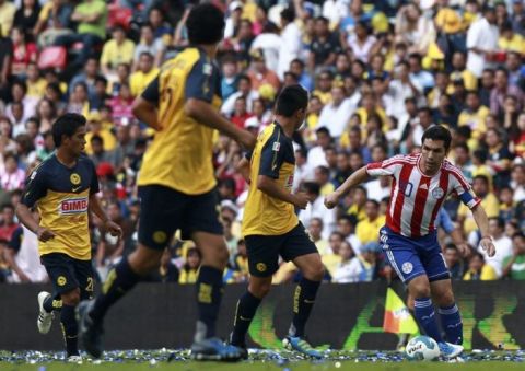 Soccer player Salvador Cabanas, right, playing for Paraguay's national team, drives with the ball during a game in his honor between Paraguay and Mexico's America at the Azteca stadium in Mexico City, Wednesday Aug. 10, 2011. Cabanas was shot in the head in January 2010 in Mexico City. (AP Photo/Christian Palma)