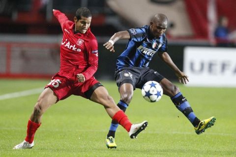 Samuel Eto'o (R) of Inter Milan fights for the ball with Roberto Rosales of Twente Enschede during their Champions League Group A soccer match in Enschede September 14, 2010. REUTERS/Michael Kooren (NETHERLANDS - Tags: SPORT SOCCER)