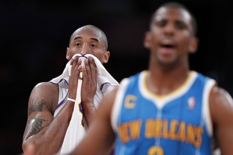 Los Angeles Lakers Kobe Bryant (L) reacts as he stands behind New Orleans Hornets Chris Paul during Game 1 of their NBA Western Conference first round playoff basketball game in Los Angeles, California April 17, 2011. REUTERS/Lucy Nicholson (UNITED STATES - Tags: SPORT BASKETBALL)