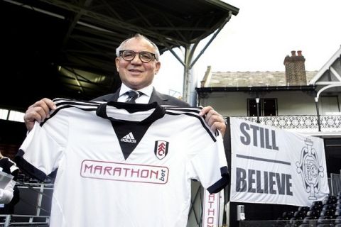 Fulham manager Felix Magath holds up a Fulham shirt following his first press conference at Craven Cottage