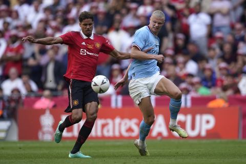 Manchester City's Erling Haaland, right, fights for the ball with Manchester United's Raphael Varane during the English FA Cup final soccer match between Manchester City and Manchester United at Wembley Stadium in London, Saturday, June 3, 2023. (AP Photo/Dave Thompson)