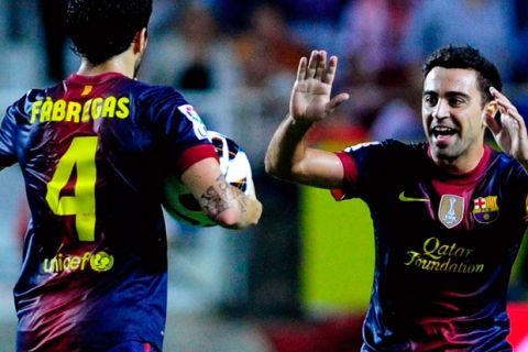 SEVILLE, SPAIN - SEPTEMBER 29:  Cesc Fabregas of FC Barcelona celebrates scoring their second goal with teammate Xavi Hernandez during the La Liga match between Sevilla FC and FC Barcelona at Estadio Ramon Sanchez Pizjuan on September 29, 2012 in Seville, Spain.  (Photo by Gonzalo Arroyo Moreno/Getty Images)