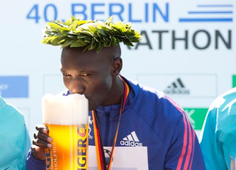 Kenya's Wilson Kipsang sips a beer as he celebrates on the podium after winning the 40th edition of the Berlin Marathon in Berlin, Germany on September 29, 2013. Kipsang set a new world record with a time of two hours, three minutes and 23 seconds. AFP PHOTO / JOHN MACDOUGALL        (Photo credit should read JOHN MACDOUGALL/AFP/Getty Images)