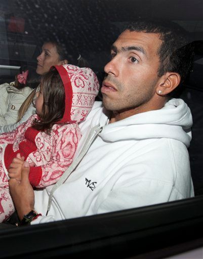 Footballer Carlos Tevez arrives at Manchester Airport, Manchester, England, Tuesday, Feb. 14, 2012. Its is reported that Tevez, who has been in Argentina without his club's permission since November 7, will resume his Manchester City career despite accusing manager Roberto Mancini of treating him "like a dog" in the incident that sparked their rift. (AP Photo/Jon Super)