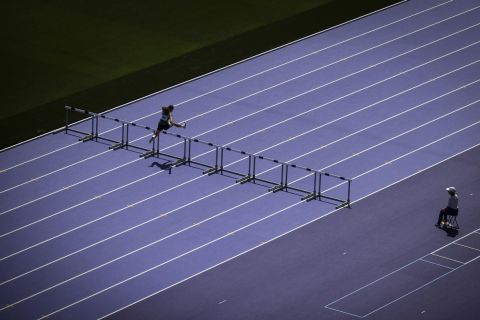 An athlete clears a hurdle during a rehearsal at the Stade de France stadium, Tuesday, June 25, 2024 in Saint-Denis, outside Paris. The Stade de France will host the athletics competitions during the Paris 2024 Olympic Games. (AP Photo/Thomas Padilla)