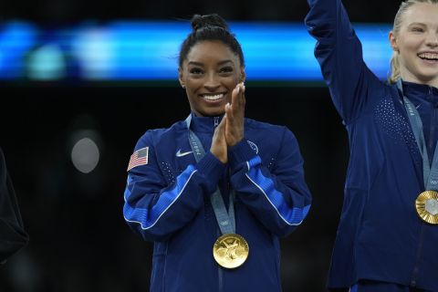 Simone Biles, of the United States, celebrates with teammates after winning the gold medal during the women's artistic gymnastics team finals round at Bercy Arena at the 2024 Summer Olympics, Tuesday, July 30, 2024, in Paris, France. (AP Photo/Charlie Riedel)