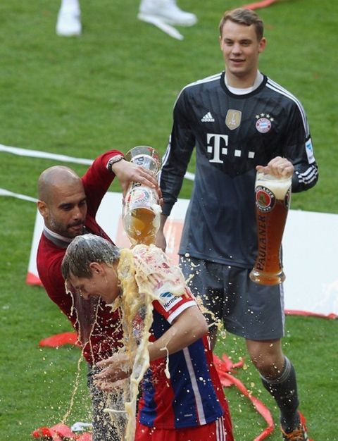 MUNICH, GERMANY - MAY 10: Head coach Josep Guardiola of Bayern Muenchen spoils beer over Toni Kroos while Manuel Neuer looks on to celebrate winning the German Championship after the Bundesliga match between FC Bayern Muenchen and VfB Stuttgart at Allianz Arena on May 10, 2014 in Munich, Germany.  (Photo by Alexandra Beier/Bongarts/Getty Images)