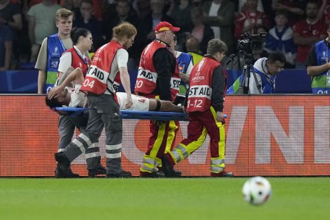 Turkey's Samet Akaydin is helped off the pitch after suffering an injury during a quarterfinal match between the Netherlands and Turkey at the Euro 2024 soccer tournament in Berlin, Germany, Saturday, July 6, 2024. (AP Photo/Ariel Schalit)