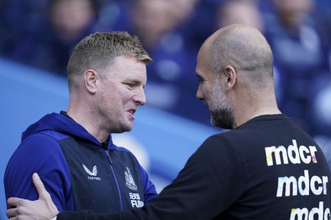 Newcastle's head coach Eddie Howe, left, and Manchester City's head coach Pep Guardiola greet each other before the start of the English Premier League soccer match between Manchester City and Newcastle United at Etihad stadium in Manchester, England, Sunday, May 8, 2022. (AP Photo/Jon Super)