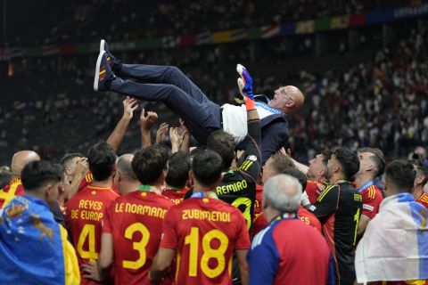 Spain players throw coach Luis de la Fuente in the air after winning the final match against England at the Euro 2024 soccer tournament in Berlin, Germany, Sunday, July 14, 2024. (AP Photo/Matthias Schrader)