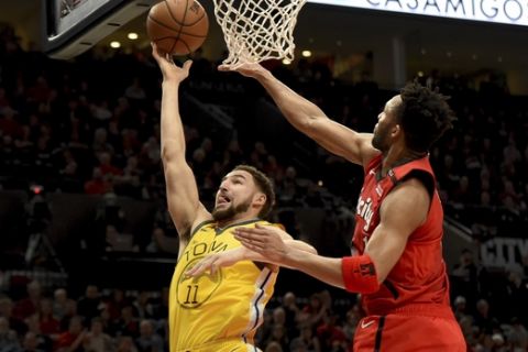 Golden State Warriors guard Klay Thompson, left, drives to the basket on Portland Trail Blazers guard Evan Turner, right, during the first half of an NBA basketball game in Portland, Ore., Saturday, Dec. 29, 2018. (AP Photo/Steve Dykes)
