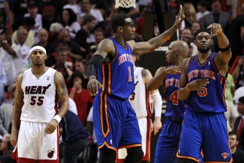 Miami Heat's Eddie House (L) looks on as New York Knicks' Amare Stoudemire (C) celebrates with teammates Chauncy Billups and Bill Walker in the fourth quarter of NBA basketball action in Miami, Florida February 27, 2011. REUTERS/Hans Deryk (UNITED STATES - Tags: SPORT BASKETBALL)