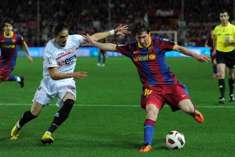 SEVILLE, SPAIN - MARCH 13:  Lionel Messi (R) of Barcelona fights for the ball with Jose Caceres of Sevilla during the la Liga match between Sevilla and Barcelona at Estadio Ramon Sanchez Pizjuan on March 13, 2011 in Seville, Spain.  (Photo by Jasper Juinen/Getty Images)