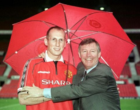 Something for a rainy day : Jaap Stam signs for Manchester United for a fee of  10 million pounds and makes manager Alex Ferguson a happyman. Photo by Dave Kendall/PA.