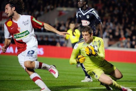 Bordeaux' goalkeeper Cedric Carrasso grabs the ball next to Brest' defender Paul Baysse during the French L1 football match Bordeaux vs. Brest on October 23, 2010 at the Chaban Delmas stadium in Bordeaux.   AFP PHOTO JEAN-PIERRE MULLER (Photo credit should read JEAN-PIERRE MULLER/AFP/Getty Images)