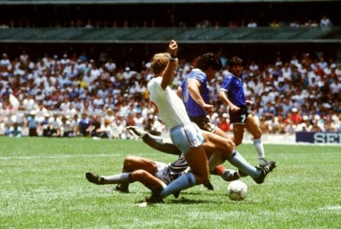 Argentina's captain Diego Maradona goes in between England's Peter Shilton and Terry Butcher to score a memorable goal.  