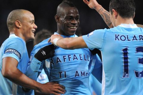 Manchester City's Italian striker Mario Balotelli (2nd L), wearing a slogan dedicated to his girlfriend, celebrates with team-mates after scoring the opening goal during the English Premier League football match between Manchester City and Blackburn Rovers at Etihad Stadium in Manchester, north-west England on February 25, 2012. AFP PHOTO/ANDREW YATES

RESTRICTED TO EDITORIAL USE. No use with unauthorized audio, video, data, fixture lists, club/league logos or live services. Online in-match use limited to 45 images, no video emulation. No use in betting, games or single club/league/player publications. (Photo credit should read ANDREW YATES/AFP/Getty Images)