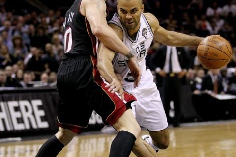 SAN ANTONIO, TX - MARCH 04:  Guard Tony Parker #9 of the San Antonio Spurs dribbles the ball against Mike Bibby #0 of the Miami Heat at AT&T Center on March 4, 2011 in San Antonio, Texas.   NOTE TO USER: User expressly acknowledges and agrees that, by downloading and or using this photograph, User is consenting to the terms and conditions of the Getty Images License Agreement.  (Photo by Ronald Martinez/Getty Images)