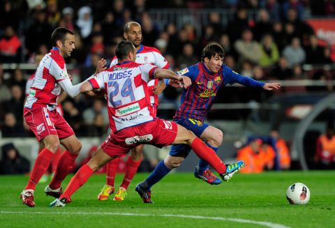 Barcelona's Argentinian forward Lionel Messi (R) vies with Granada's French defender Noe Elias Pamarot (L) and Granada's midfielder Moises Hurtado Perez (C) during the Spanish league football match FC Barcelona vs Granada CF on March 20, 2012 at the Camp Nou stadium in Barcelona. AFP PHOTO/ JOSEP LAGO (Photo credit should read JOSEP LAGO/AFP/Getty Images)