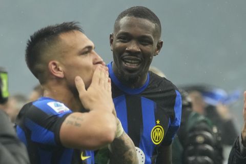 Inter Milan's Marcus Thuram, right, and Inter Milan's Lautaro Martinez celebrate at the end of the Serie A soccer match between AC Milan and Inter Milan at the San Siro stadium in Milan, Italy, Monday, April 22, 2024. (AP Photo/Luca Bruno)