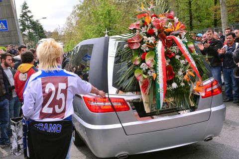 Friends and supporters pay hommage to Italian footballer Piermario Morosini as the hearse carrying his coffin leaves after the funeral service at a church on April 19, 2012  in Bergamo.  The 25-year-old, who played for second division team Livorno and was on loan from Udinese, died during a match at Pescara on April 14. AFP PHOTO / GIUSEPPE CACACE (Photo credit should read GIUSEPPE CACACE/AFP/Getty Images)