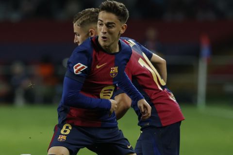 Barcelona's Gavi, front right, duels for the ball with Sevilla's Jose Angel Carmona during a Spanish La Liga soccer match between Barcelona and Sevilla at the Olimpic Lluis Companys stadium in Barcelona, Spain, Sunday, Oct. 20, 2024. (AP Photo/Joan Monfort)