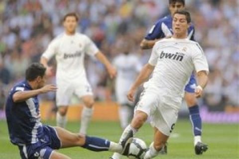 Real Madrid's Cristiano Ronaldo from Portugal, right, duels for the ball with Tenerife's Carlos Bellvis from Spain during their Spanish La Liga soccer match at the Santiago Bernabeu Stadium, in Madrid, Saturday, Sept. 26, 2009. (AP Photo/Daniel Ochoa de Olza)