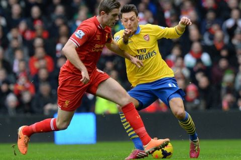 Arsenal's German midfielder Mesut Ozil (R) vies with Liverpool's English midfielder Jordan Henderson  during the English Premier League football match between Liverpool and Arsenal at Anfield in Liverpool, northwest England, on February 8, 2014.  AFP PHOTO / ANDREW YATES

RESTRICTED TO EDITORIAL USE. No use with unauthorized audio, video, data, fixture lists, club/league logos or live services. Online in-match use limited to 45 images, no video emulation. No use in betting, games or single club/league/player publications.        (Photo credit should read ANDREW YATES/AFP/Getty Images)