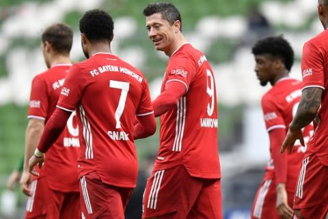 Bayern's Robert Lewandowski, center, celebrates with Serge Gnabry after scoring his side's third goal during the German Bundesliga soccer match between Werder Bremen and Bayern Munich in Bremen, Germany, Saturday, March 13, 2021. (AP Photo/Martin Meissner, Pool)