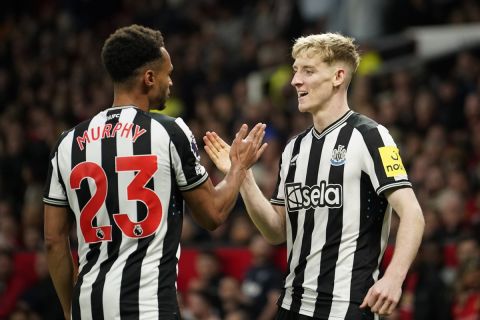 Newcastle's Anthony Gordon, right, celebrates with Newcastle's Jacob Murphy after scoring his side's opening goal during the English Premier League soccer match between Manchester United and Newcastle United, in Manchester, England, Wednesday, May 15, 2024. (AP Photo/Dave Thompson)