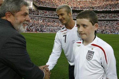 England mascot Robert Sebbage (R) watches as Brazil's President Luiz Inacio Lula da Silva (2nd L) greets England's David Beckham before the start of a friendly international soccer match against Brazil at Wembley Stadium in London in this June 1, 2007 file photo. British teenager Sebbage was stabbed to death while on holiday in Greece, local media reported. Sebbage, who had neuropathic bowel disorder, became an England mascot for the friendly match against Brazil in 2007 through a children's charity which grants wishes for seriously and terminally ill children. REUTERS/Ricardo Stuckert-Brazilian Presidency/Handout/Files  (BRITAIN - Tags: SPORT SOCCER CRIME LAW) FOR EDITORIAL USE ONLY. NOT FOR SALE FOR MARKETING OR ADVERTISING CAMPAIGNS