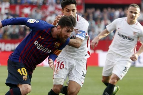 Barcelona forward Lionel Messi and Sevilla's Jeus Navas fight for the ball during La Liga soccer match between Sevilla and Barcelona at the Ramon Sanchez Pizjuan stadium in Seville, Spain. Saturday, February 23, 2019. (AP Photo/Miguel Morenatti)