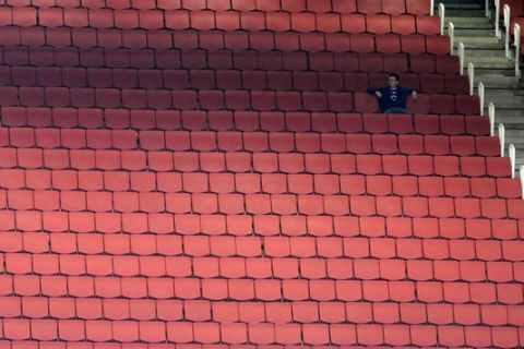 A fan waits for the start of the English League Cup soccer match between Arsenal and Shrewsbury Town at the Emirates stadium, London, Tuesday, Sept. 20, 2011. (AP Photo/Tom Hevezi)