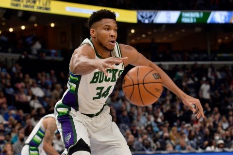 Milwaukee Bucks forward Giannis Antetokounmpo (34) reaches for the ball in the first half of an NBA basketball game against the Memphis Grizzlies, Saturday, March 26, 2022, in Memphis, Tenn. (AP Photo/Brandon Dill)