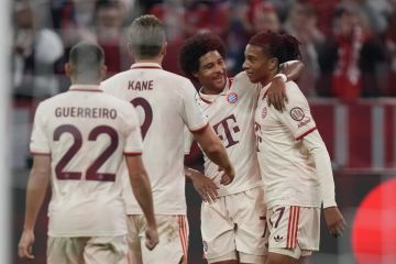 Bayern's Michael Olise, right, is congratulated by teammate Bayern's Serge Gnabry after scoring his sides 5th goal during the Champions League opening phase soccer match between Bayern Munich and GNK Dinamo at the Allianz Arena in Munich, Germany Tuesday, Sept. 17, 2024. (AP Photo/Matthias Schrader)