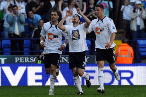 Bolton Wanderers' Israeli midfielder Tamir Cohen (c) celebrates scoring the winning goal by revealing a t-shirt in honour of his late father, former footballer Avi Cohen, who died after a motorbike accident in December during the English Premier League football match between Bolton Wanderers and Arsenal at the Reebok Stadium in Bolton, north west England, on April 24, 2011. AFP PHOTO/PAUL ELLIS - FOR EDITORIAL USE ONLY Additional licence required for any commercial/promotional use or use on TV or internet (except identical online version of newspaper) of Premier League/Football League photos. Tel DataCo +44 207 2981656. Do not alter/modify photo. (Photo credit should read PAUL ELLIS/AFP/Getty Images)