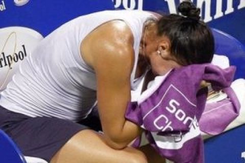 Dinara Safina of Russia sits down injured as she retires from her singles match against Jelena Jankovic of Serbia at the WTA Tennis Championships, in Doha, Qatar Wednesday, Oct. 28, 2009.  (AP Photo/Kirsty Wigglesworth)