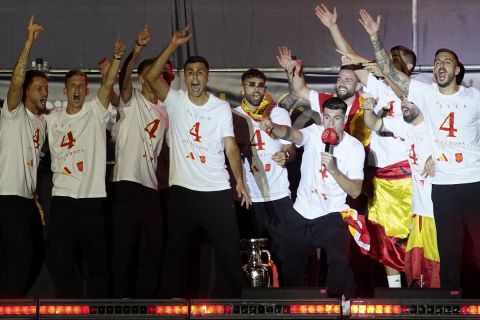 Spain's team captain Alvaro Morata, with the microphone, introduces player Rodri, center, to the fans during celebrations of the Spanish team's European soccer championship title on a stage at Cibeles square in Madrid, Monday, July 15, 2024. Spain defeated England in the final of the Euro 2024 soccer tournament in Berlin on Sunday evening. (AP Photo/Andrea Comas)