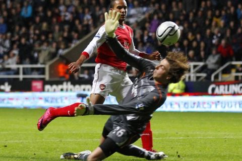 Arsenal's Theo Walcott puts the ball past goalkeeper Wojciech Szczesny to score against Newcastle United during their English League Cup soccer match at St James' Park stadium in Newcastle, north east England  October 27, 2010. REUTERS/David Moir (BRITAIN - Tags: SPORT SOCCER)