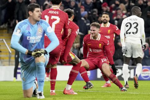 Liverpool's Alexis Mac Allister, center, celebrates after scoring the opening goal during the Champions League opening phase soccer match between Liverpool and Real Madrid at Anfield Stadium, Liverpool, England, Wednesday, Nov. 27, 2024. (AP Photo/Jon Super)