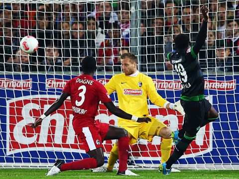 FREIBURG IM BREISGAU, GERMANY - SEPTEMBER 26: Joseph Akpala (R) of Bremen scores his team's first goal against goalkeeper Oliver Baumann and Fallou Diagne of Freiburg during the Bundesliga match between SC Freiburg and SV Werder Bremen at MAGE SOLAR Stadium on September 26, 2012 in Freiburg im Breisgau, Germany.  (Photo by Alex Grimm/Bongarts/Getty Images)