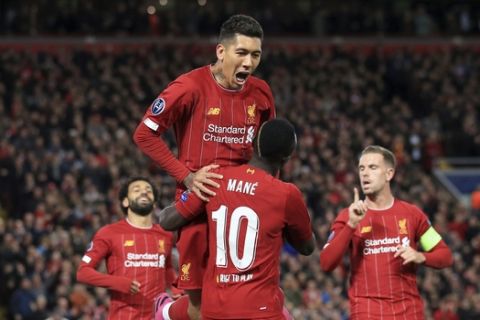 Liverpool's Sadio Mane, center down, celebrates with Liverpool's Roberto Firmino, top, after scoring his side's opening goal during the Champions League group E soccer match between Liverpool and Red Bull Salzburg at Anfield stadium in Liverpool, England, Wednesday, Oct. 2, 2019. (AP Photo/Jon Super)